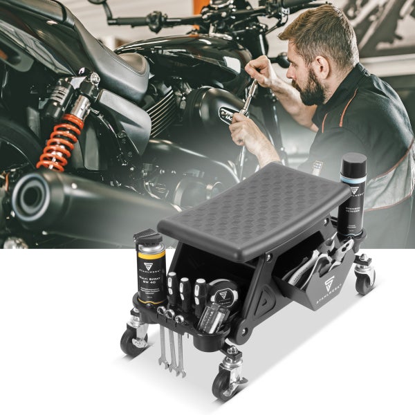 Werkstatthocker mit Rollen, Werkzeugen und einer Person, die an einem Motorrad arbeitet