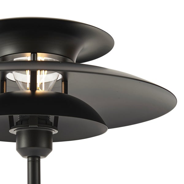 Schwarze Außenleuchte aus Metall mit mehrstufigem Schirmdesign und sichtbarem Leuchtmittel.