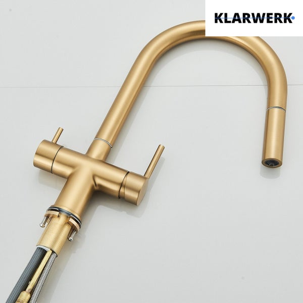 Küchenarmatur mit hohem Bogenauslauf und ausziehbarer Brause in Gold gebürstet. Klarwerk Logo.