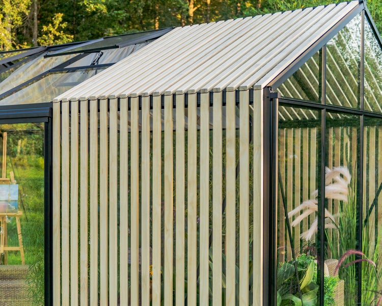 Modernes Gewächshaus mit schwarzem Rahmen und Sonnenschutz aus hellen Holzlamellen an der Seite und auf dem Dach.