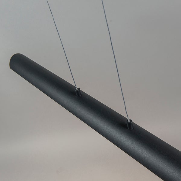 Nahaufnahme einer schwarzen Pendelleuchte mit schlankem, zylindrischem Design.