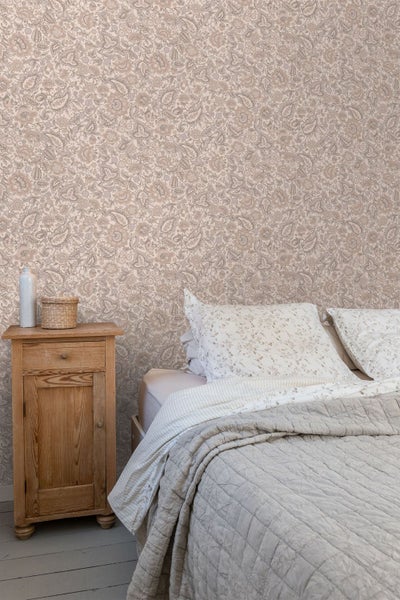 Tapete mit floralem Paisley-Muster in einem wohnlich eingerichteten Zimmer mit einer Holzkommode und einem gepolsterten Sessel.