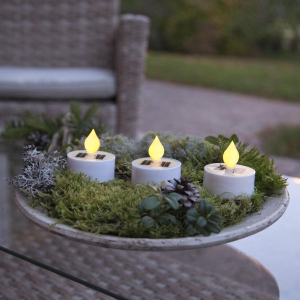 Dekoration mit drei Solar LED Kerzen auf einem Teller