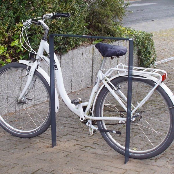Weißes Fahrrad geparkt an einem Fahrradständer
