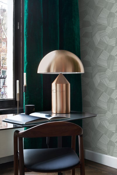 Einrichtungsszene mit Schreibtisch, Lampe, Stuhl, Vorhängen und geometrischer Tapete