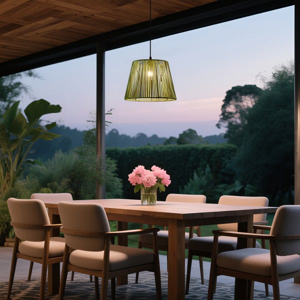 Moderner Außen-Essbereich mit Holztisch, Polsterstühlen und grüner Pendelleuchte auf einer Terrasse mit Blick auf einen Garten bei Dämmerung.