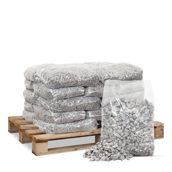 Transparente Säcke mit grauem Kies auf einer Holzpalette gestapelt sowie ein einzelner Sack und loser Kies im Vordergrund.