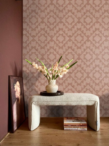 Wohnraum mit gemusterter Vliestapete, strukturierte Oberfläche, dekoriert mit Polsterbank, Blumenvase und gerahmtem Bild vor einer Wand