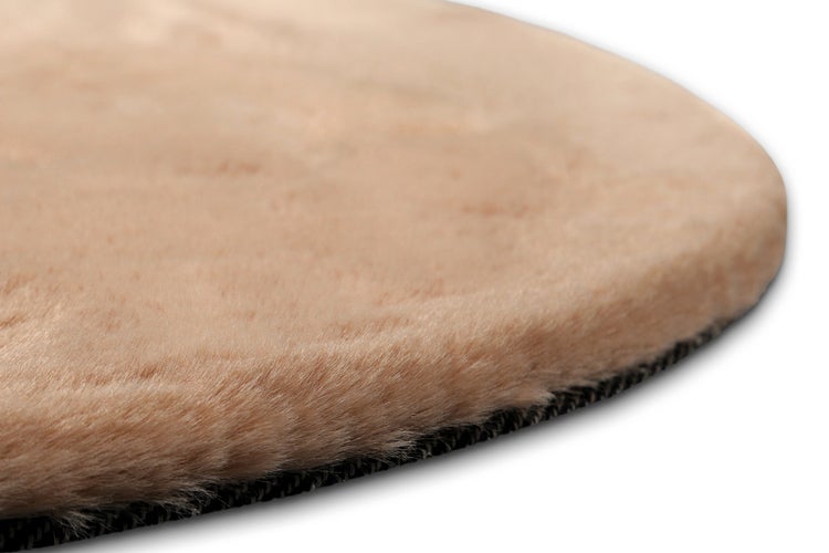 Weicher runder Hochflor-Teppich aus Kunstfell mit dunkler Unterseite.