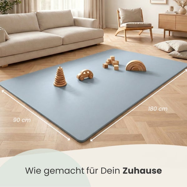 Rechteckige Spielmatte, 90 mal 180 Zentimeter, mit Holzspielzeug in einem modern eingerichteten Wohnzimmer mit Sofa und Parkettboden.
