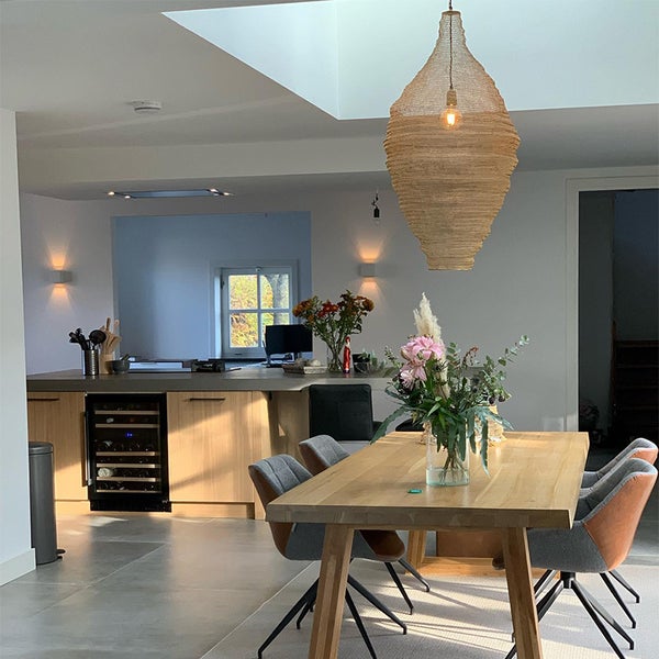 Heller Wohnraum mit Esstisch, Stühlen, Pendelleuchte und Küchentheke