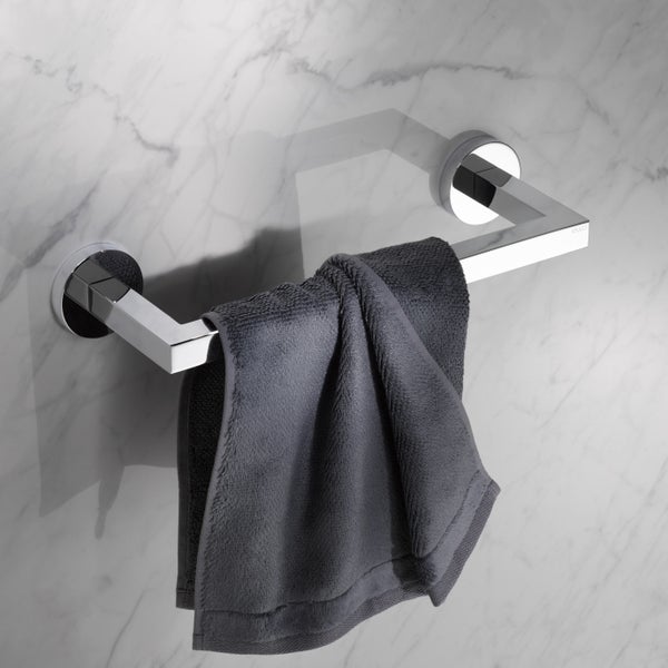 Wandmontierter Handtuchhalter aus Metall mit eckigem Design und Handtuch an einer Fliesenwand mit Marmoroptik.