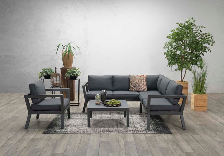 Modernes Garten-Lounge-Set aus Metall mit Ecksofa, Sessel und Couchtisch, graue Polster, arrangiert auf Holzboden mit Pflanzen.