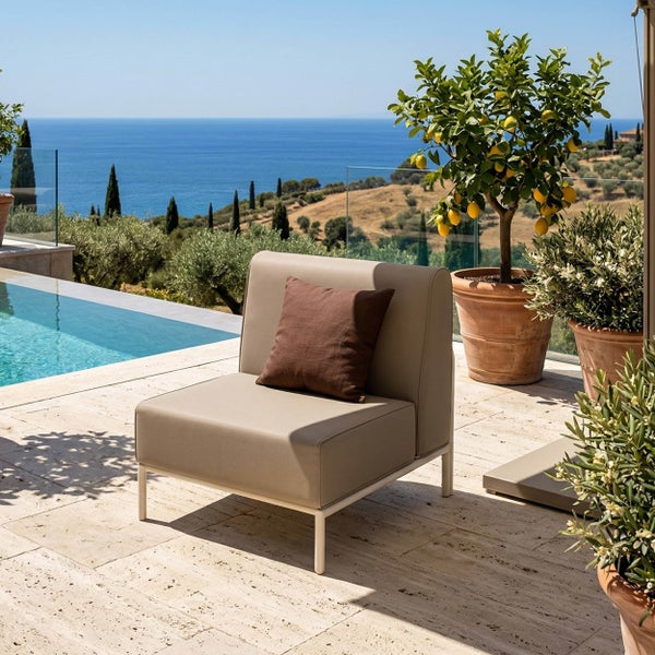 Moderner Outdoor-Lounge-Sessel in Beige mit braunem Kissen auf einer hellen Terrasse neben einem Pool und einem Zitronenbaum im Tontopf.