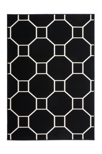 Modernes Wohnzimmer mit hellem Sofa, rotem Sessel und einem auffälligen schwarzen Teppich mit geometrischem Muster auf dem Boden.
