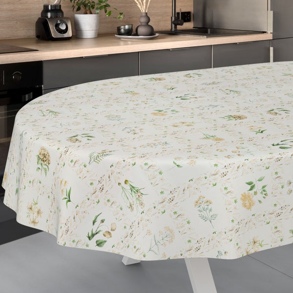 Ovale Tischdecke mit botanischem Blumenmuster auf einem Tisch in einer hellen, modernen Küche mit Schränken und Holzarbeitsplatte.