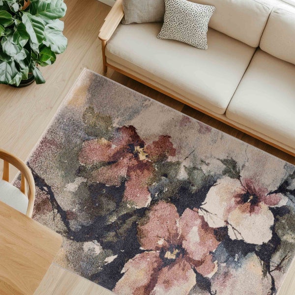 Innenaufnahme eines Wohnzimmers mit einem Teppich mit Blumenmuster, einer Couch und einem Holztisch.