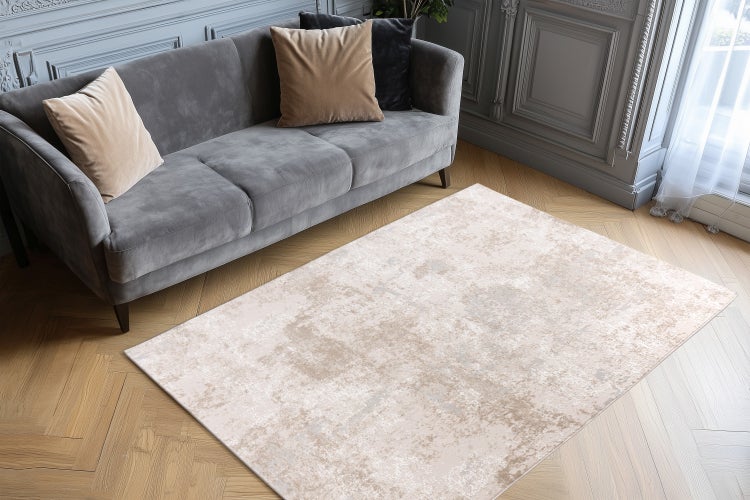 Wohnzimmer mit hell gemustertem Teppich auf Parkettboden, Sofa mit Kissen und klassischer Wandgestaltung in einem elegant eingerichteten Raum.