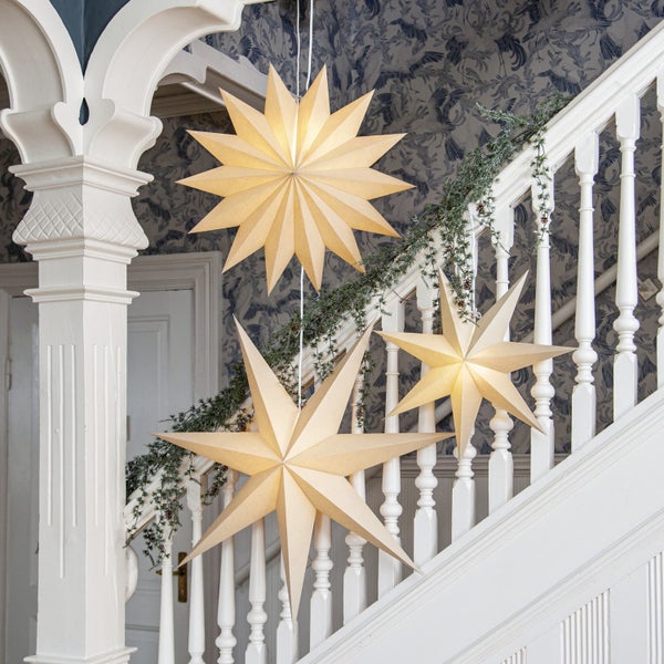 Dekorative Papiersterne auf Treppe mit Geländer und Girlande