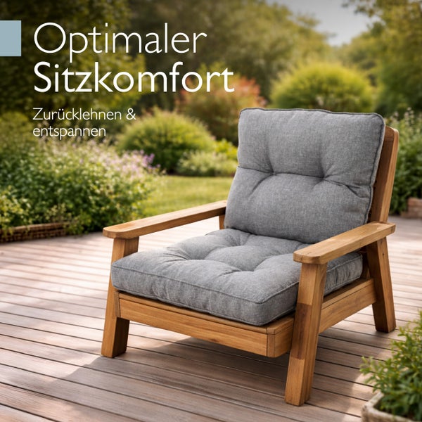 Gartenstuhl aus Holz mit grauen Polstern auf einer Holzterrasse im Garten.