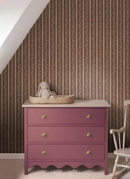 Tapete mit vertikalen Streifen und Blumenranken in einem Kinderzimmer mit rosa Kommode und Stofftier.