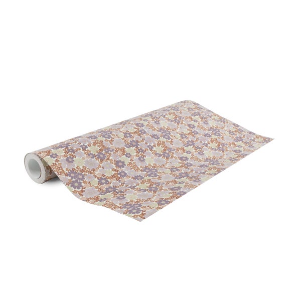 Vliestapete mit feinem Blumenmuster, Rolle teilweise ausgerollt.