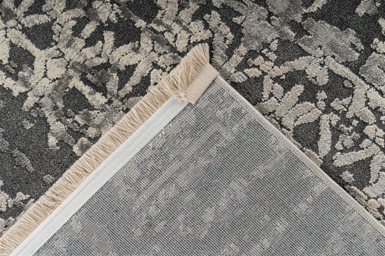 Nahaufnahme eines gemusterten Teppichs mit Fransen und gewebter Rückseite.