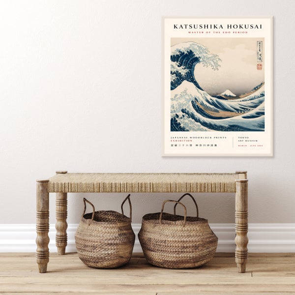 Gerahmtes Wandbild mit Katsushika Hokusai Kunstdruck Die große Welle vor Kanagawa über einer Holzbank mit zwei geflochtenen Körben.