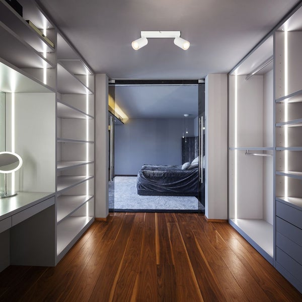 2-flammiger Deckenstrahler in weiß in einem modernen begehbaren Kleiderschrank mit Holzfußboden und LED-Regalbeleuchtung.