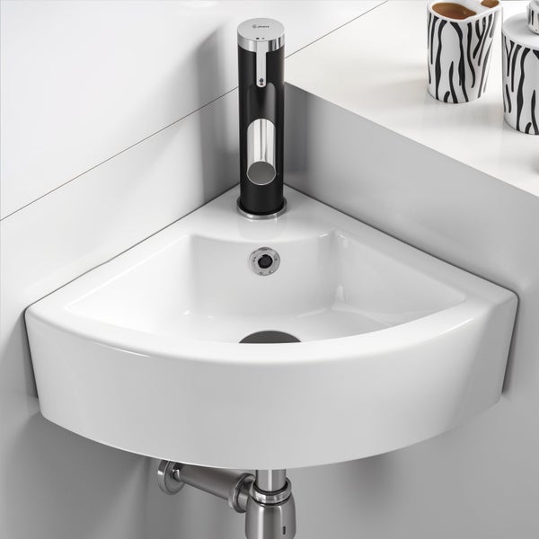 Eckwaschbecken aus Keramik mit Armatur zur Wandmontage in einem Badezimmer.
