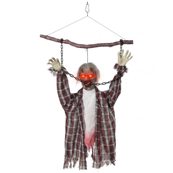 Hängende Halloween Zombie Dekoration mit leuchtenden Augen und Ketten an einem Ast.