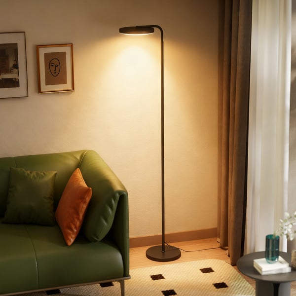 Wohnzimmer mit Stehlampe, Sofa, Kissen und Dekoration