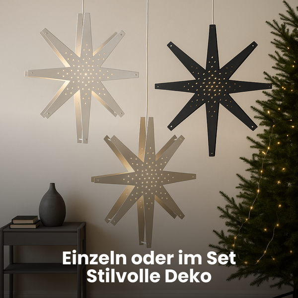 Dekorative Sternleuchten in verschiedenen Ausführungen hängen im Raum, eine davon neben einem Weihnachtsbaum.