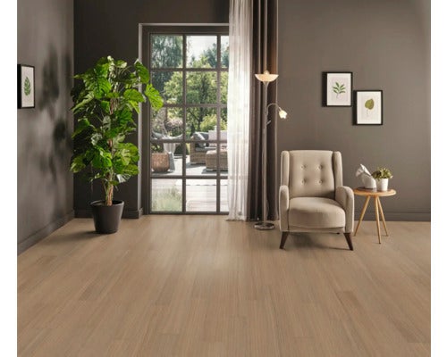 Wohnzimmer mit Holzfußboden, Sessel, Stehlampe und Zimmerpflanze