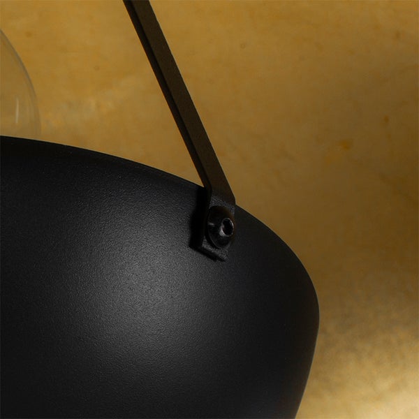 Detailaufnahme einer schwarzen Hängelampe mit Aufhängung.