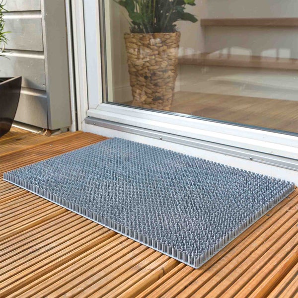 Fußabstreifer vor einer Tür auf einem Holzdeck