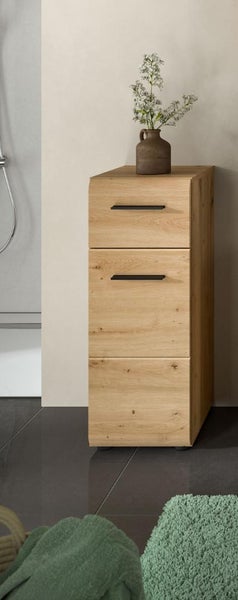 Schmaler Badezimmer-Midischrank in Eiche-Optik mit drei Fächern und zwei schwarzen Griffleisten in einem hellen, aufgeräumten Badezimmer.