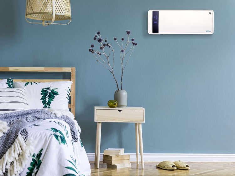 Schlafzimmer mit Bett, Nachttisch, Zimmerpflanze, Lampe und Klimaanlage an der Wand