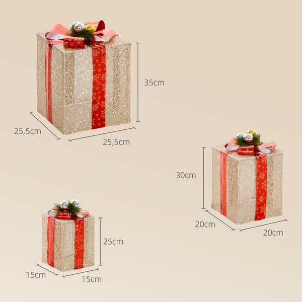 Drei goldene LED-Geschenkboxen, rote Schleife. Maße: 25,5 mal 25,5 mal 35, 20 mal 20 mal 30 und 15 mal 15 mal 25 Zentimeter.