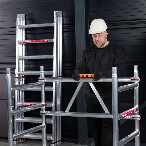 Mann mit Wasserwaage und Baugerüst