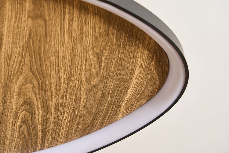 Nahaufnahme einer modernen ovalen LED-Leuchte mit einer Oberfläche in Holzoptik und einem integrierten Lichtband.