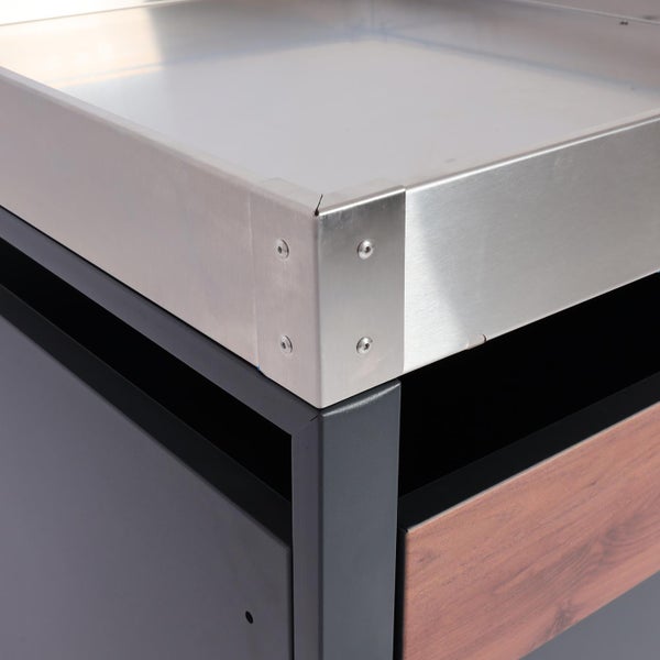 Detailaufnahme eines Grillschranks mit Edelstahloberfläche und Holzschublade