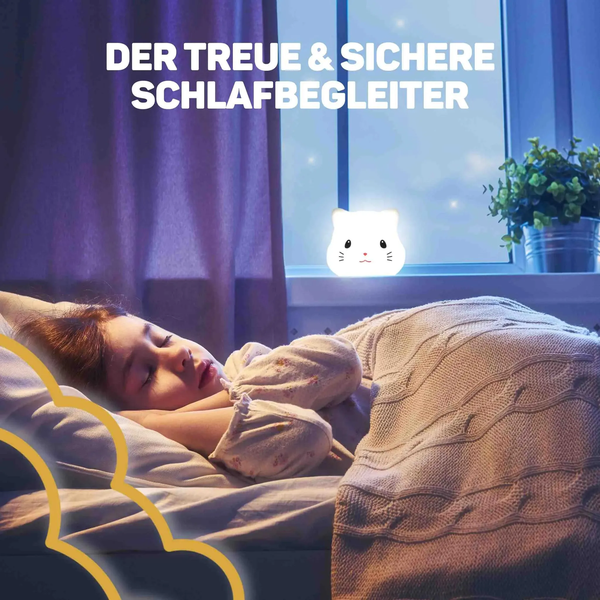 Kind schläft im Bett neben einem leuchtenden katzenförmigen Nachtlicht auf der Fensterbank.