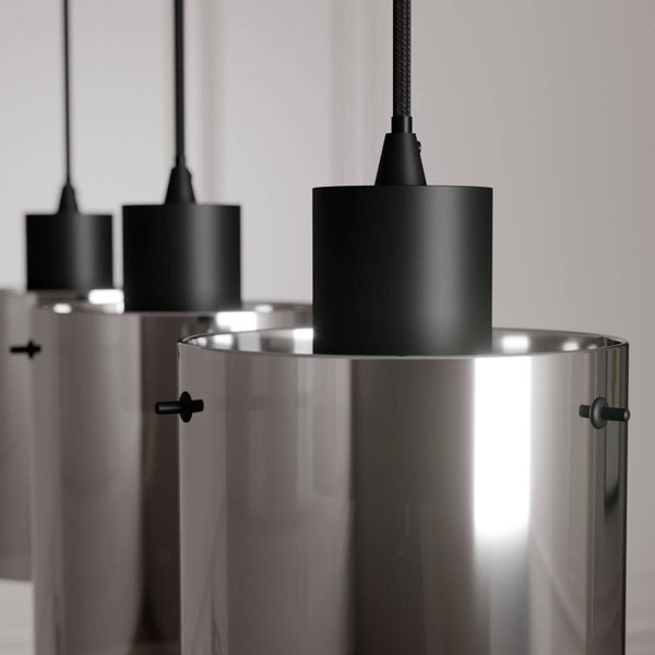 Nahaufnahme von drei modernen Pendelleuchten mit zylindrischen Schirmen aus reflektierendem Glas und schwarzen Fassungen.