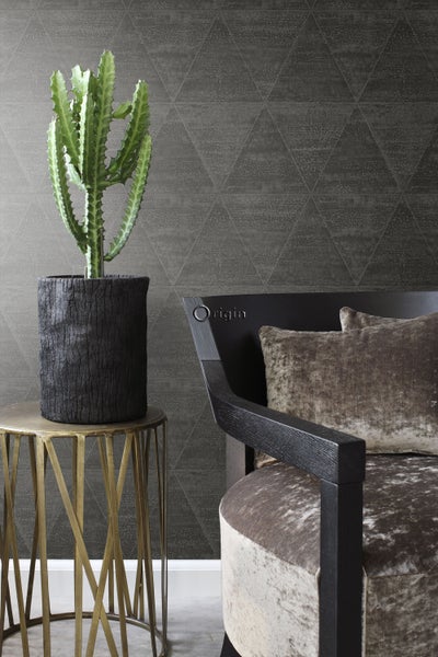 Dekorative Szene mit Kaktus in Topf auf Beistelltisch neben Sessel vor Tapete