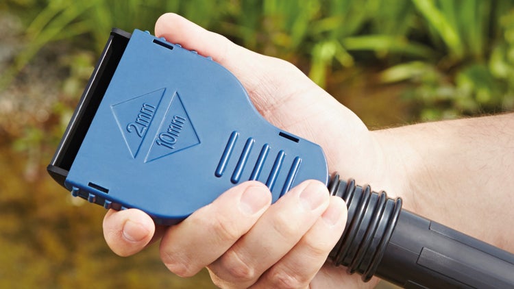 Hand hält eine blaue Teichsauger-Düse mit Einstellungen für 2 Millimeter und 10 Millimeter Schmutzpartikel.