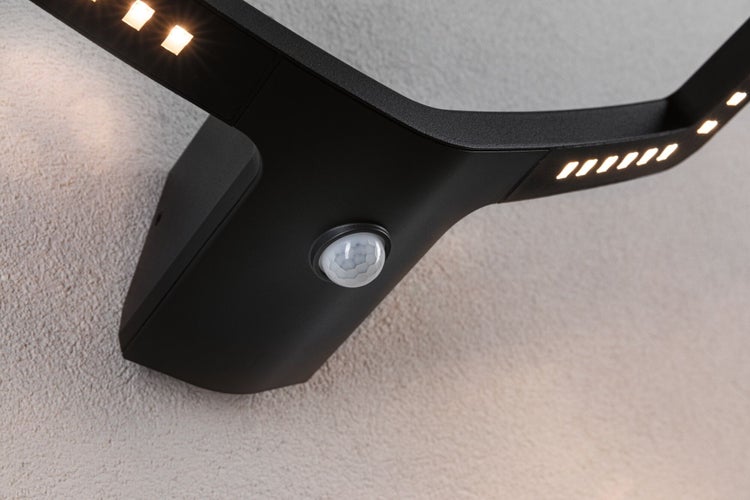 Schwarze LED-Außenwandleuchte mit Bewegungsmelder an einer Wand