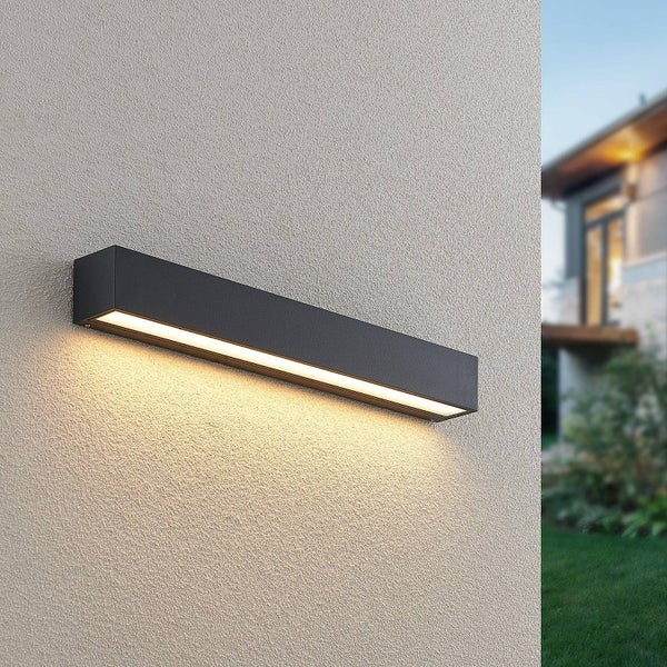 Moderne rechteckige Außenwandleuchte in Schwarz an einer strukturierten Fassade mit warmweißem Lichtschein nach unten.
