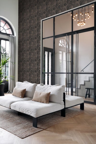 Heller Wohnraum mit Sofa, Teppich und gemusterter Tapete