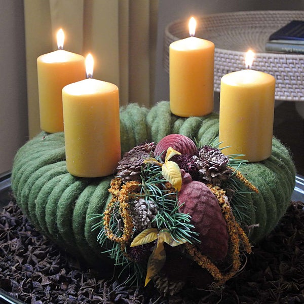 Adventskranz mit vier gelben Kerzen, Tannenzapfen und Sternanis